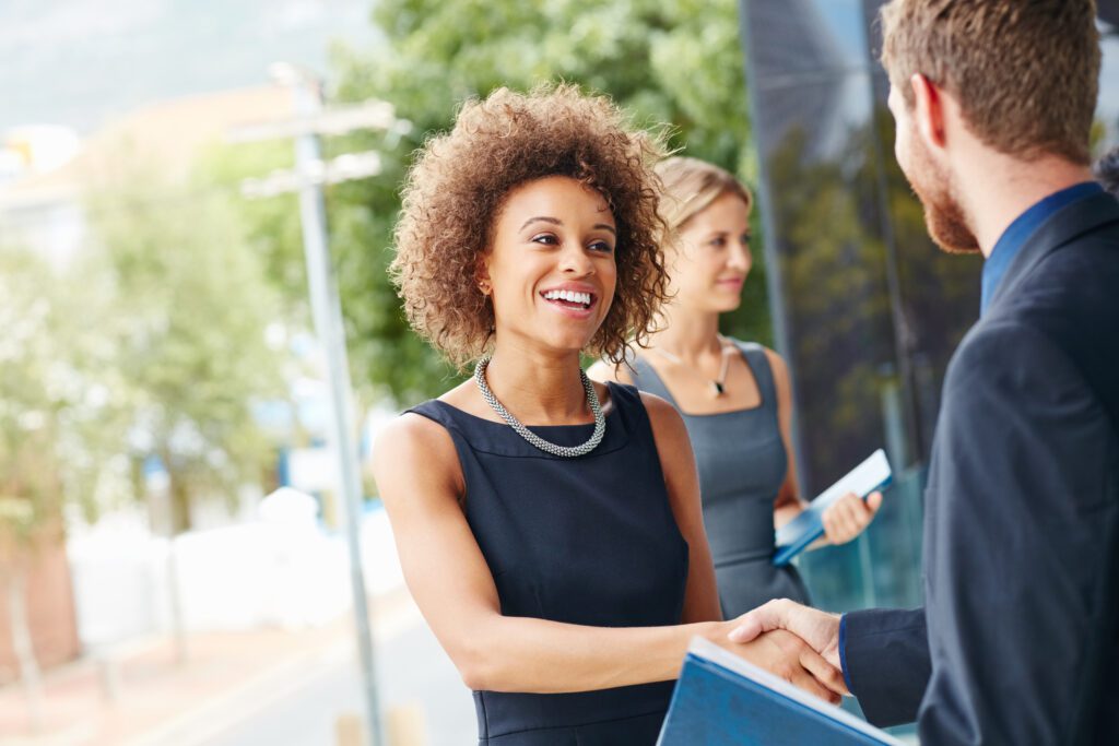 Shot of a businesswoman and businessman shaking hands outdoors.