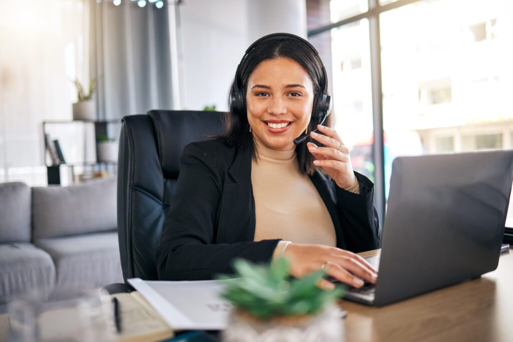 Happy woman, call center and laptop with headphones in remote work for customer service or support at home office. Friendly female person, consultant or freelance agent smile in online advice or help.