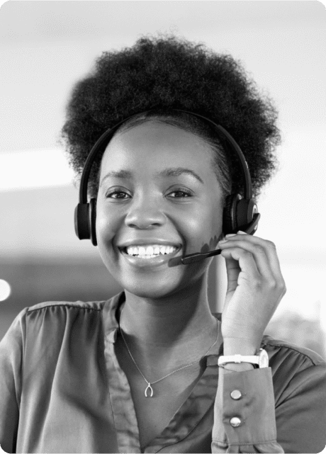 A Young black woman smiling on a call using headphones